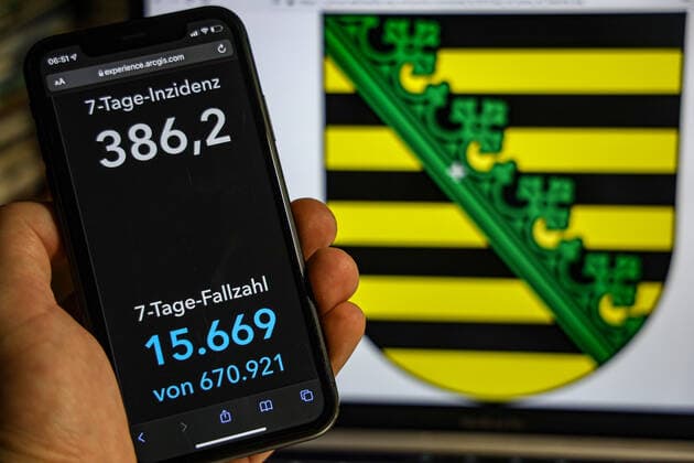 Coronavirus in Germany Covid 19 Dashboard of the Robert Koch Institute DEU, Germany, Saxony 23 01 2022 The 7-day incidence for the state Cases last 7 days 100 000 p.e. is displayed on an iPhone, in the background the state coat of arms