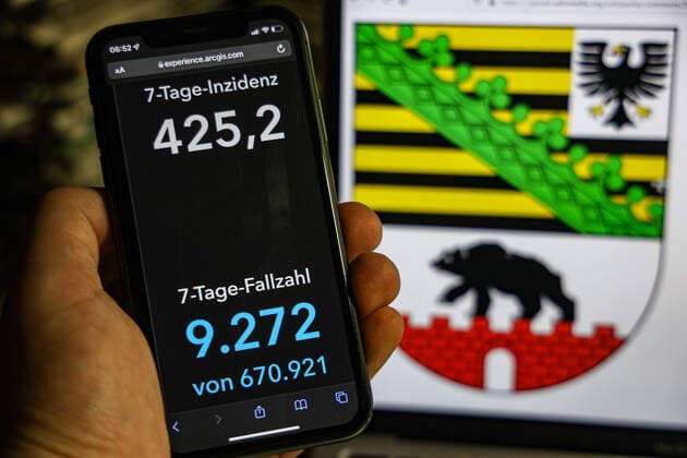 Coronavirus in Germany Covid 19 Dashboard of the Robert Koch Institute DEU, Germany, Saxony Anhalt 23 01 2022 The 7-day incidence for the state Cases last 7 days 100 000 p.e. is displayed on an iPhone, in the background the state coat of arms
