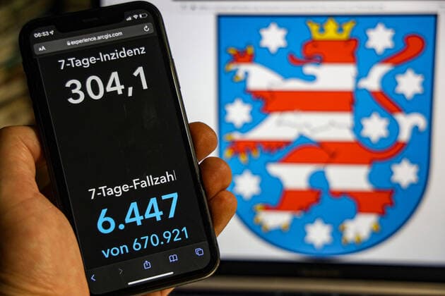 Coronavirus in Germany Covid 19 Dashboard of the Robert Koch Institute DEU, Germany, Thuringia 23 01 2022 The 7-day incidence for the state Cases last 7 days 100 000 p.e. is displayed on an iPhone, in the background the state coat of arms