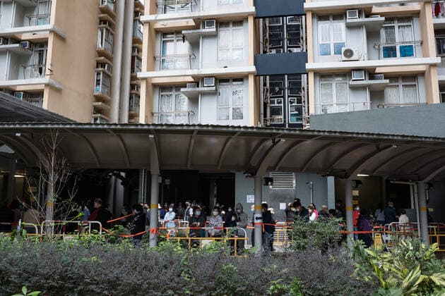 January 23, 2022, Hong Kong, China: Residents wait in a line to test for the COVID-19 outside a building placed under lockdown at Kwai Chung Estate public housing complex in Hong Kong..Beginning with the Yat Kwai House at Kwai Chung Estate, the five-day Covid-19 lockdown now has been extended to neighboring buildings. After the health authorities found over 100 Covid-19 positive cases in one day at the the Kwai Chung public housing estate, four other buildings in the estate were placed under an overnight lockdown for residents to be tested. Hong Kong China - ZUMAs197 20220123_zaa_s197_051 Copyright: xDominicxChiux