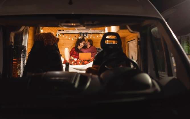IMAGO Creative: Herbst, Touren mit dem Camper IMAGO Creative: Countdown bis Weihnachten, Nach Hause reisen Man kissing girlfriend in camper van on vacation model released property released, EGHF00301