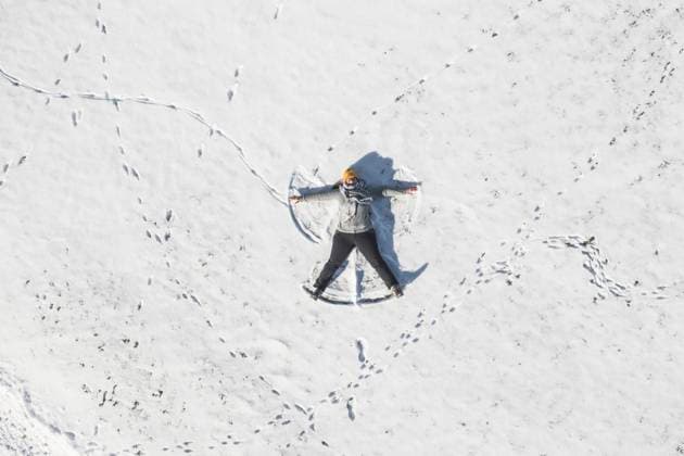 Drone view of adult woman making snow angel model released, ASCF01614