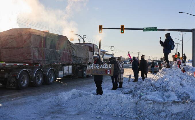January 25, 2022, Winnipeg, MB, CANADA: Protesters of COVID-19 restrictions, and supporters of Canadian truck drivers protesting the COVID-19 vaccine mandate cheer on a convoy of trucks on their way to Ottawa, on the Trans-Canada Highway west of Winnipeg, Manitoba, Tuesday January 25, 2022. Winnipeg CANADA  - ZUMAc35_ 20220125_zaf_c35_040 Copyright: xDavidxLipnowskix