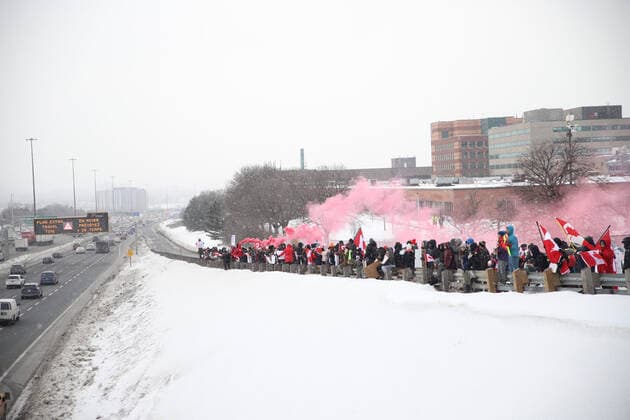 January 27, 2022, Toronto, ON, Canada: Protesters and supporters against a COVID-19 vaccine mandate for cross-border truckers cheer as a parade of trucks and vehicles pass outside of Toronto, Ontario, on Wednesday, Jan. 27, 2022. Toronto Canada - ZUMAs181 20220127_zea_s181_005 Copyright: xImagespacex