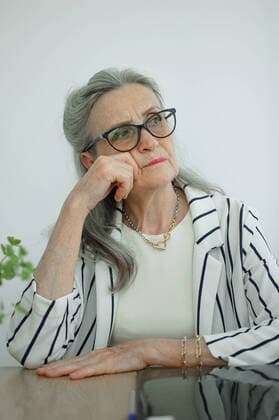 IMAGO Creative: Internationaler Frauenmonat, Gesundheit, Frauen in der Menopause Tired senior grey haired businesswoman in striped jacket with eyeglasses is working in her office sitting at the desk and feeling bad due to menopause, menopause relief concept Tired senior grey haired businesswoman in striped jacket with eyeglasses is working in her office sitting at the desk and feeling bad due to menopause, menopause relief concept. Copyright: xx 39926898