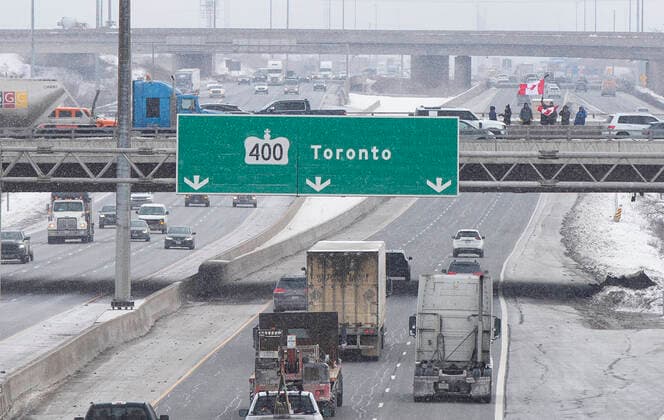 (220128) -- ONTARIO, Jan. 28, 2022 -- People gather on a bridge over Highway 400 in support of truckers, who are on their way to Ottawa for the freedom convoy protest, in Vaughan, Ontario, Canada, on Jan. 27, 2022. The freedom convoy was sparked by outrage over a vaccine mandate recently imposed on Canadian-U.S. cross-border truckers. (Photo by Xinhua) CANADA-ONTARIO-FREEDOM CONVOY-TRUCKERS PROTEST ZouxZheng 