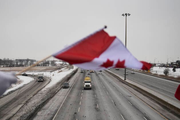 The Freedom Rally Supporters waiving Canadian Flag and greeting the drivers on highway 400 during The Freedom Rally to protest the mandatory vaccine policy imposed on the Canadian truckers returning from USA to avoid a two week quarantine in Vaughan-Ontario in Canada. Vaughan Canada  Copyright: xArindamxShivaanix originalFilename: shivaanibahuguna-notitle220127_npnVe.jpg
