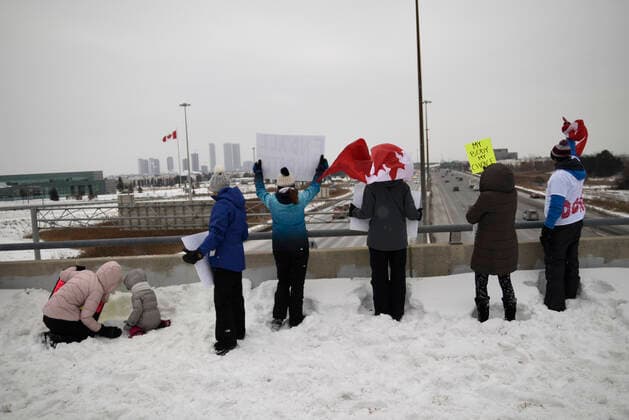 The Freedom Rally Supporters waiving Canadian Flag and greeting the drivers on highway 400 during The Freedom Rally to protest the mandatory vaccine policy imposed on the Canadian truckers returning from USA to avoid a two week quarantine in Vaughan-Ontario in Canada. Vaughan Canada  Copyright: xArindamxShivaanix originalFilename: shivaanibahuguna-notitle220127_np82e.jpg