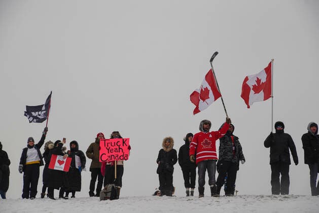 The Freedom Rally Supporters waiving Canadian Flag and greeting the drivers on highway 400 during The Freedom Rally to protest the mandatory vaccine policy imposed on the Canadian truckers returning from USA to avoid a two week quarantine in Vaughan-Ontario in Canada. Vaughan Canada  Copyright: xArindamxShivaanix originalFilename: shivaanibahuguna-notitle220127_npdIx.jpg