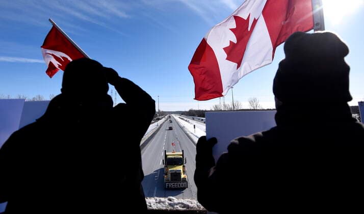 January 28, 2022, Ottawa, ON, CAN: People wave flags as a truck participating in the Freedom Convoy, a cross-country convoy protesting a federal vaccine mandate for truckers, makes its way along Highway 416 in Ottawa, Friday, Jan. 28, 2022. Ottawa CAN  - ZUMAc35_ 20220128_zaf_c35_036 Copyright: xJustinxTangx