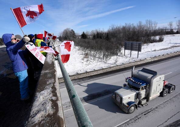January 28, 2022, Ottawa, ON, CAN: People wave flags as a truck participating in the Freedom Convoy, a cross-country convoy protesting a federal vaccine mandate for truckers, makes its way along Highway 416 in Ottawa, Friday, Jan. 28, 2022. Ottawa CAN  - ZUMAc35_ 20220128_zaf_c35_037 Copyright: xJustinxTangx