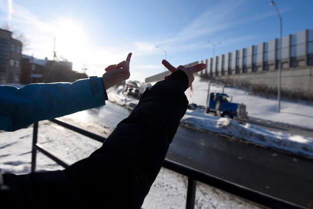 January 28, 2022, Ottawa, ON, CAN: Students walking home from school perform a gesture towards trucks honking in traffic as a cross-country convoy protesting measures taken by authorities to curb the spread of COVID-19 arrives in Ottawa en route to Parliament Hill, on Friday, Jan. 28, 2022. Ottawa CAN  - ZUMAc35_ 20220128_zaf_c35_081 Copyright: xJustinxTangx