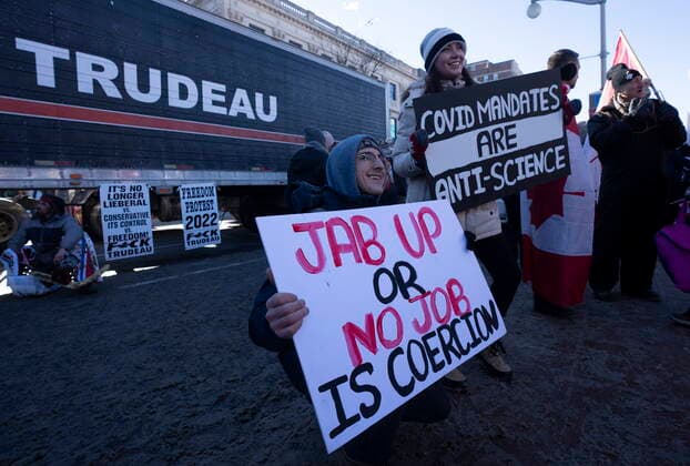 January 29, 2022, Ottawa, ON, Canada: People pose in front of a tractor trailer as they participate in a cross-country truck convoy protesting measures taken by authorities to curb the spread of COVID-19 and vaccine mandates near Parliament Hill in Ottawa on Saturday, Jan. 29, 2022. Ottawa Canada  - ZUMAc35_ 20220129_zaf_c35_052 Copyright: xAdrianxWyldx