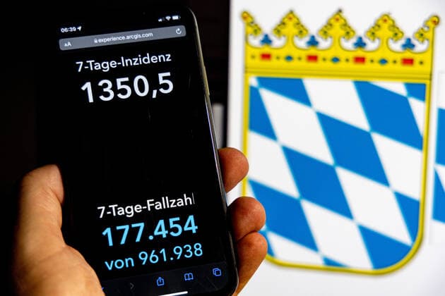 Coronavirus in Deutschland - Covid-19-Dashboard des Robert Koch-Institut DEU, Deutschland, Bayern 30.01.2022: Die 7-Tage-Inzidenz für das Bundesland (Fälle letzte 7 Tage 100.000 EW) wird auf einem iPhone angezeigt, im Hintergrund das Landeswappen
