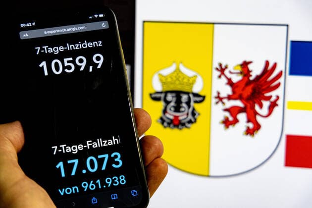 Coronavirus in Deutschland - Covid-19-Dashboard des Robert Koch-Institut DEU, Deutschland, Mecklenburg-Vorpommern 30.01.2022: Die 7-Tage-Inzidenz für das Bundesland (Fälle letzte 7 Tage 100.000 EW) wird auf einem iPhone angezeigt, im Hintergrund das Landeswappen