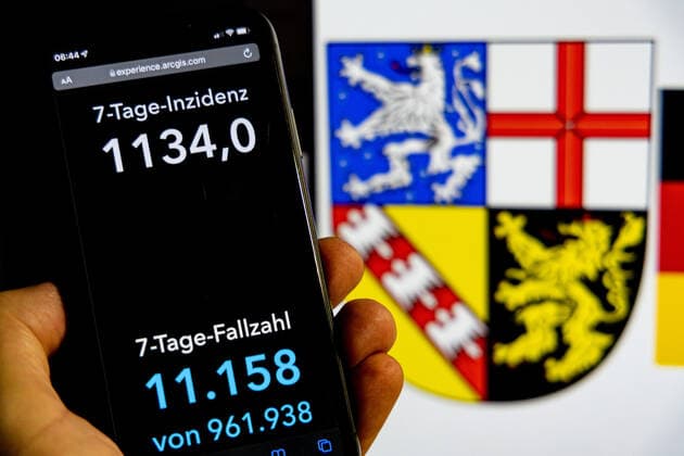 Coronavirus in Deutschland - Covid-19-Dashboard des Robert Koch-Institut DEU, Deutschland, Saarland 30.01.2022: Die 7-Tage-Inzidenz für das Bundesland (Fälle letzte 7 Tage 100.000 EW) wird auf einem iPhone angezeigt, im Hintergrund das Landeswappen