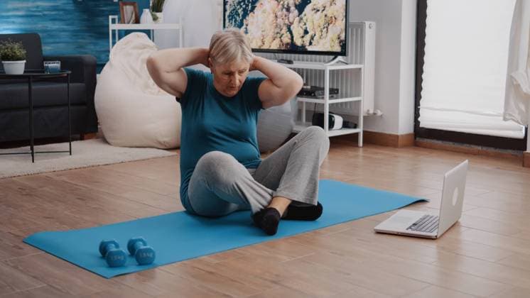 Old person looking at video with workout lesson on laptop Old person looking at video with workout lesson on laptop and doing physical exercise from home. Elder woman watching coach training online to practice fitness activity and sport program Copyright: xx 43957672