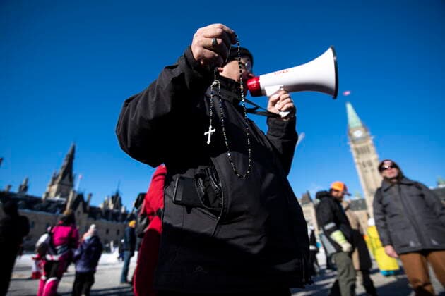 January 30, 2022, Ottawa, ON, CAN: A person leads a group in the saying of the Rosary during a rally against COVID-19 restrictions on Parliament Hill, which began as a cross-country convoy protesting a federal vaccine mandate for truckers, in Ottawa on Sunday, Jan. 30, 2022. Ottawa CAN  - ZUMAc35_ 20220130_zaf_c35_020 Copyright: xJustinxTangx