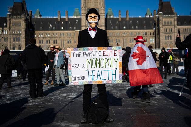January 29, 2022, Ottawa, ON, CAN: A person wearing a Monopoly Man mask holds a sign during a rally against COVID-19 restrictions on Parliament Hill, which began as a cross-country convoy protesting a federal vaccine mandate for truckers, in Ottawa, on Saturday, Jan. 29, 2022. Ottawa Canada  - ZUMAc35_ 20220129_zaf_c35_016 Copyright: xJustinxTangx