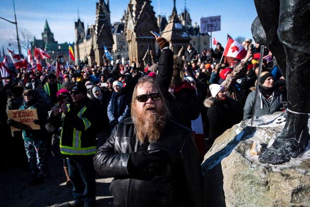 January 30, 2022, Ottawa, Canada: A person holds their hand to their heart during a singing of O Canada during a rally against COVID-19 restrictions on Parliament Hill, which began as a cross-country convoy protesting a federal vaccine mandate for truckers, in Ottawa on Sunday, Jan. 30, 2022. Ottawa Canada  - ZUMAc35_ 20220130_zaf_c35_006 Copyright: xJustinxTangx