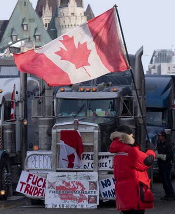 February 1, 2022, Ottawa, ON, Canada: A man waves a Canadian flag in front of trucks parked in the downtown core, onTuesday, Feb. 1, 2022 in Ottawa. As organizers behind the demonstration that has seized the nation s capital say they are preparing to stick around even longer by distributing fuel and supplies to the trucks clogging up Ottawa streets, politicians at all levels of government are asking them to roll out. Ottawa Canada  - ZUMAc35_ 20220201_zaf_c35_032 Copyright: xAdrianxWyldx