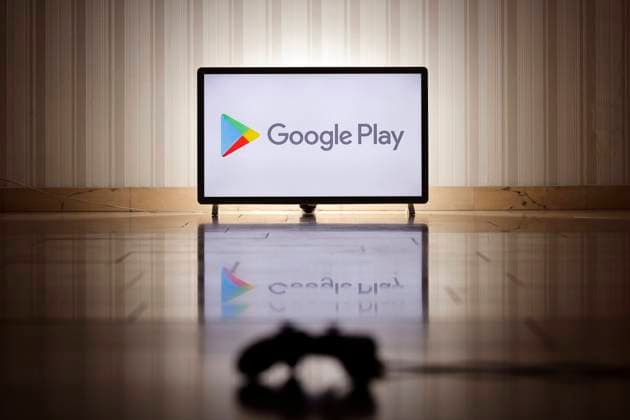 Das Logo des App Stores Google Play, der u.a. Spiele anbietet, auf einem Bildschirm, im Vordergrund ein Gaming-Controller. (Symbolbild, Symbolfoto) Köln, 01.02.2022 Foto:xC.xHardtx xFuturexImage