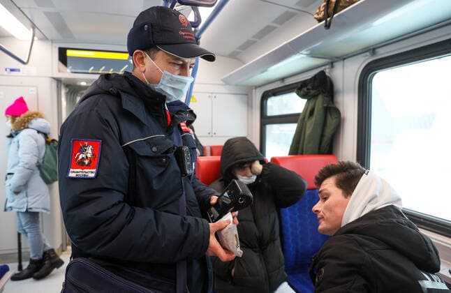 Coronavirus in Russland, Kontrolle der Einhaltung der Vorschriften im Ã–PNV MOSCOW, RUSSIA - FEBRUARY 2, 2022: A Mosgortrans transport company inspector checks compliance with the face mask requirement on a train on Line D1 (Belorussko-Savyolovsky Diameter) of the Moscow Central Diameters (MCD). The face mask mandate applies to public transport nationwide to prevent the spread of the novel coronavirus. Gavriil Grigorov TASS  TS120E4F
