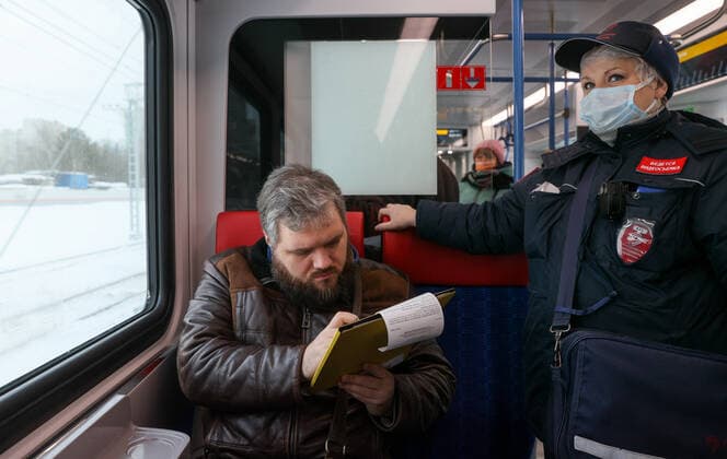 Coronavirus in Russland, Kontrolle der Einhaltung der Vorschriften im Ã–PNV MOSCOW, RUSSIA - FEBRUARY 2, 2022: A Mosgortrans transport company inspector checks compliance with the face mask requirement on a train on Line D1 (Belorussko-Savyolovsky Diameter) of the Moscow Central Diameters (MCD). The face mask mandate applies to public transport nationwide to prevent the spread of the novel coronavirus. Gavriil Grigorov TASS  TS120E52