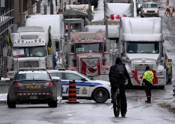 February 2, 2022, Ottawa, ON, Canada: A cyclist rides towards a police barricade where trucks are lined up near Parliament hill on Wednesday, Feb. 2, 2022 in Ottawa. Ottawa Canada  - ZUMAc35_ 20220202_zaf_c35_062 Copyright: xAdrianxWyldx