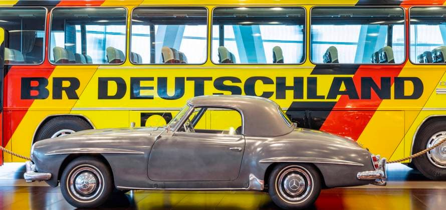 Mercedes Museum Stuttgart. Mercedes-Benz 190 SL (1959) von NASA-Astronaut David Randolph Scott. Mercedes-Benz 0 302 Mannschafts-Reisebus (1974). Teambus der deutschen Nationalmannschaft bei der Fußball-WM 1974. (Architektur: Ben van Berkel, Architekturbüro UNStudio). Stuttgarts meistbesuchtes Museum ist Teil der Mercedes-Benz Welt in Untertürkheim. DEU; Deutschland, Baden-Württemberg, Stuttgart.