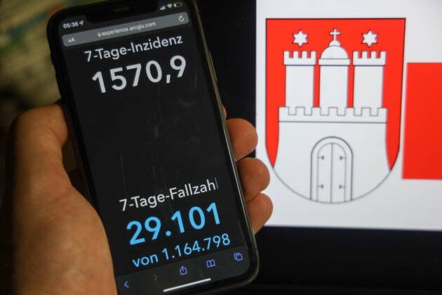 Coronavirus in Deutschland - Covid-19-Dashboard des Robert Koch-Institut DEU, Deutschland, Hamburg 06.02.2022: Die 7-Tage-Inzidenz für das Bundesland (Fälle letzte 7 Tage 100.000 EW) wird auf einem iPhone angezeigt, im Hintergrund das Landeswappen