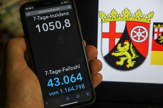 Coronavirus in Deutschland - Covid-19-Dashboard des Robert Koch-Institut DEU, Deutschland, Rheinland-Pfalz 06.02.2022: Die 7-Tage-Inzidenz für das Bundesland (Fälle letzte 7 Tage 100.000 EW) wird auf einem iPhone angezeigt, im Hintergrund das Landeswappen
