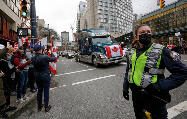 (220206) -- VANCOUVER, Feb. 6, 2022 -- A police officer wearing a face mask is seen on duty during the rally and convoy against COVID-19 vaccine mandate in downtown Vancouver, Canada, Feb. 5, 2022. In solidarity with protesters in downtown Ottawa, anti COVID-19 vaccine mandates and restrictions supporters in Vancouver took part in vehicle convoys and rallies protesting against Canadian government s vaccine mandate for essential workers crossing the Canada-U.S. border. (Photo by Xinhua) CANADA-VANCOUVER-COVID-19-CONVOY PROTEST LiangxSen 