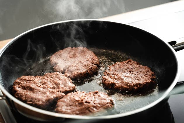 06 February 2022: Vegan hamburger patties made from pea protein, vegetable vegan meat replacement burger is fried in a hot pan with oil *** Vegane Hamburger Pattys aus Erbsenprotein, pflanzlich vegan Fleisch Ersatz Burger wird in einer heißen Pfanne mit Öl angebraten