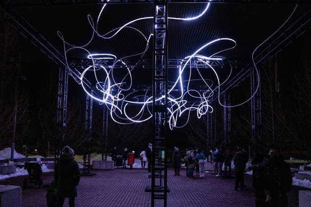 February 7, 2022, Toronto, Canada: People seen at an outdoor art installation, ˜Pressure™ by Hans E. Madsen and Frederik D. Hougs, a piece consisting of a 300-metre long string of pulsating RGB-LED lights resembling a doodle, wrapped around a large construction. .The Nordic Lights outdoor winter exhibition, is a display of Nordic and Canadian light art at the Toronto Harbourfront Centre, co-produced with Fjord Studio. Toronto Canada - ZUMAs197 20220207_zaa_s197_476 Copyright: xKatherinexChengx