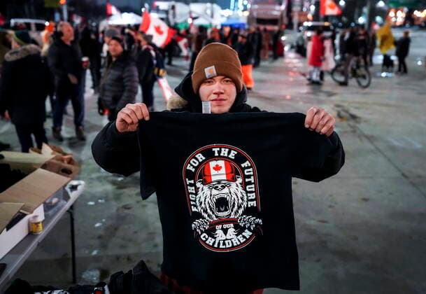 February 10, 2022, WINDSOR, ON, CANADA: A Trucker supporter sells T-shirts as they block the access leading from the Ambassador Bridge, linking Detroit and Windsor, as truckers and their supporters continue to protest against the COVID-19 vaccine mandates and restrictions in Windsor, Ont., on Thursday, February 10, 2022. WINDSOR CANADA  - ZUMAc35_ 20220210_zaf_c35_050 Copyright: xNathanxDenettex