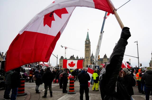 February 11, 2022, Ottawa, Canada: A person waves a Canadian flag in front of Parliament Hill on the 15th day of a protest against COVID-19 measures that has grown into a broader anti-government protest. Ottawa Canada  - ZUMAc35_ 20220211_zaf_c35_164 Copyright: xJustinxTangx