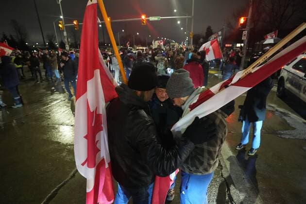 February 11, 2022, WINDSOR, ON, CANADA: People pray as truckers and supporters block the access leading from the Ambassador Bridge, linking Detroit and Windsor, as truckers and their supporters continue to protest against the COVID-19 vaccine mandates and restrictions in Windsor, Ont., on Friday, February 11, 2022. WINDSOR CANADA  - ZUMAc35_ 20220211_zaf_c35_200 Copyright: xNathanxDenettex