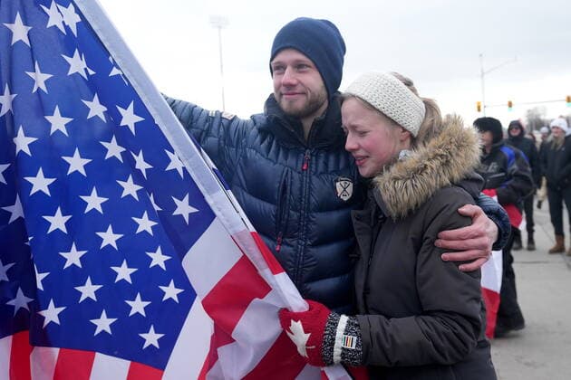 February 12, 2022, Windsor, ON, CANADA: A supporter holding an American flag cries as police officers enforce an injunction against their demonstration, which has blocked traffic across the Ambassador Bridge by protesters against COVID-19 restrictions, in Windsor, Ont., Saturday, Feb. 12, 2022. Windsor CANADA  - ZUMAc35_ 20220212_zaf_c35_112 Copyright: xNathanxDenettex