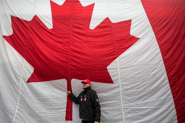February 12, 2022, EDMONTON, AB, CANADA: A protestor against COVID-19 restrictions poses for photos in front of big Canada flag in Edmonton Alta, on Saturday February 12, 2021. EDMONTON CANADA  - ZUMAc35_ 20220212_zaf_c35_215 Copyright: xJasonxFransonx