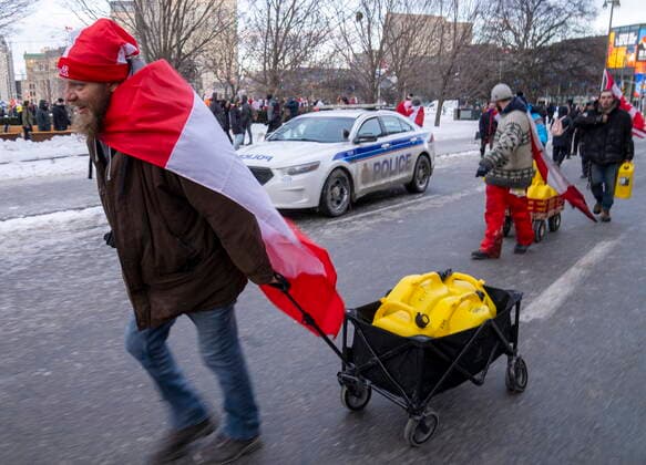 February 12, 2022, Ottawa, on, Canada: Protesters haul fuel past a police car during the COVID-19 anti-mandate protest on Parliament Hill in Ottawa on Saturday, February 12, 2022. Ottawa Canada  - ZUMAc35_ 20220212_zaf_c35_250 Copyright: xFrankxGunnx