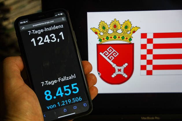 Coronavirus in Deutschland - Covid-19-Dashboard des Robert Koch-Institut DEU, Deutschland, Bremen 13.02.2022: Die 7-Tage-Inzidenz für das Bundesland (Fälle letzte 7 Tage 100.000 EW) wird auf einem iPhone angezeigt, im Hintergrund das Landeswappen