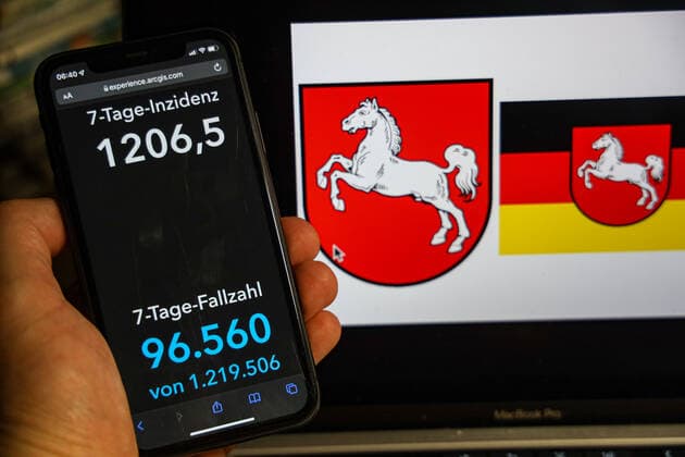 Coronavirus in Deutschland - Covid-19-Dashboard des Robert Koch-Institut DEU, Deutschland, Niedersachsen 13.02.2022: Die 7-Tage-Inzidenz für das Bundesland (Fälle letzte 7 Tage 100.000 EW) wird auf einem iPhone angezeigt, im Hintergrund das Landeswappen