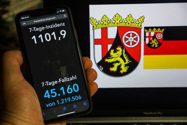 Coronavirus in Deutschland - Covid-19-Dashboard des Robert Koch-Institut DEU, Deutschland, Rheinland-Pfalz 13.02.2022: Die 7-Tage-Inzidenz für das Bundesland (Fälle letzte 7 Tage 100.000 EW) wird auf einem iPhone angezeigt, im Hintergrund das Landeswappen