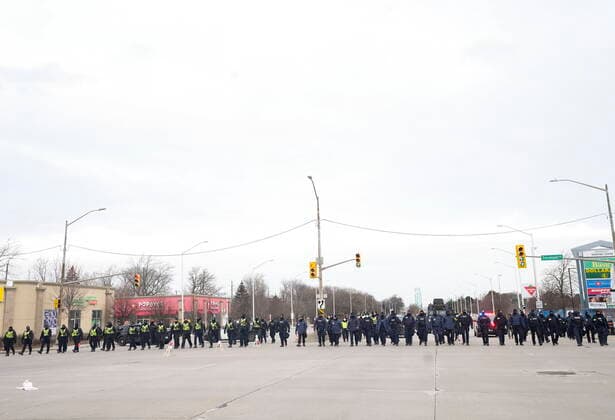 February 13, 2022, WINDSOR, ON, CANADA: Police walk the line to remove all truckers and supporters after a court injunction gave police the power to enforce the law after protesters blocked the access leading from the Ambassador Bridge, linking Detroit and Windsor, as truckers and their supporters continue to protest against COVID-19 vaccine mandates and restrictions, in Windsor, Ont., Sunday, Feb. 13, 2022. WINDSOR CANADA  - ZUMAc35_ 20220213_zaf_c35_039 Copyright: xNathanxDenettex