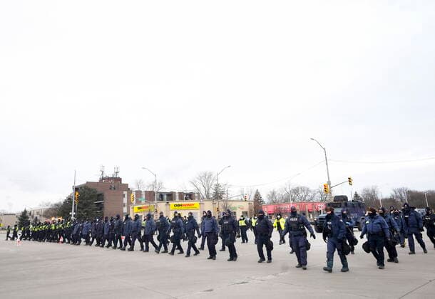 February 13, 2022, WINDSOR, ON, CANADA: Police walk the line to remove all truckers and supporters after a court injunction gave police the power to enforce the law after protesters blocked the access leading from the Ambassador Bridge, linking Detroit and Windsor, as truckers and their supporters continue to protest against COVID-19 vaccine mandates and restrictions, in Windsor, Ont., Sunday, Feb. 13, 2022. WINDSOR CANADA  - ZUMAc35_ 20220213_zaf_c35_038 Copyright: xNathanxDenettex