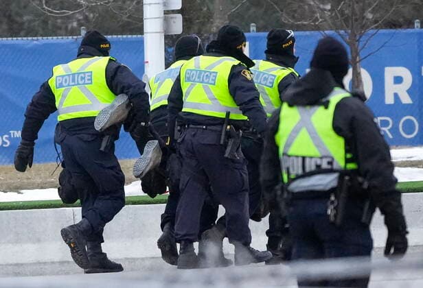 February 13, 2022, WINDSOR, ON, CANADA: Police arrest a person as they walk the line to remove all truckers and supporters after a court injunction gave police the power to enforce the law after protesters blocked the access leading from the Ambassador Bridge, linking Detroit and Windsor, as truckers and their supporters continue to protest against COVID-19 vaccine mandates and restrictions, in Windsor, Ont., Sunday, Feb. 13, 2022. WINDSOR CANADA  - ZUMAc35_ 20220213_zaf_c35_041 Copyright: xNathanxDenettex