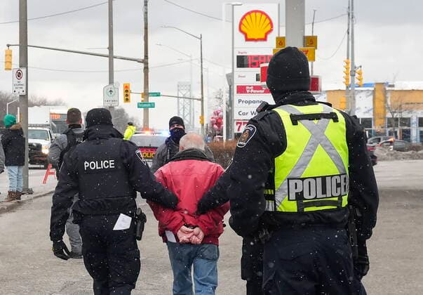 February 13, 2022, WINDSOR, ON, CANADA: A protester is arrested by as police remove truckers and supporters after a court injunction gave police the power to enforce the law after blocking the access leading from the Ambassador Bridge, linking Detroit and Windsor, as truckers and their supporters continue to protest against the COVID-19 vaccine mandates and restrictions in Windsor, Ont., on Sunday, February 13, 2022. WINDSOR CANADA  - ZUMAc35_ 20220213_zaf_c35_063 Copyright: xNathanxDenettex