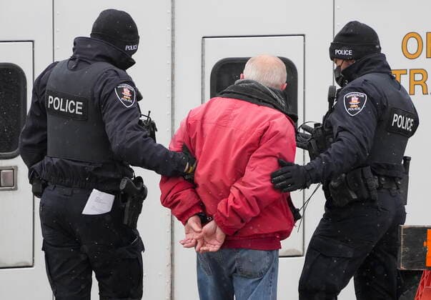 February 13, 2022, WINDSOR, ON, CANADA: A protester is arrested by as police remove truckers and supporters after a court injunction gave police the power to enforce the law after blocking the access leading from the Ambassador Bridge, linking Detroit and Windsor, as truckers and their supporters continue to protest against the COVID-19 vaccine mandates and restrictions in Windsor, Ont., on Sunday, February 13, 2022. WINDSOR CANADA  - ZUMAc35_ 20220213_zaf_c35_061 Copyright: xNathanxDenettex