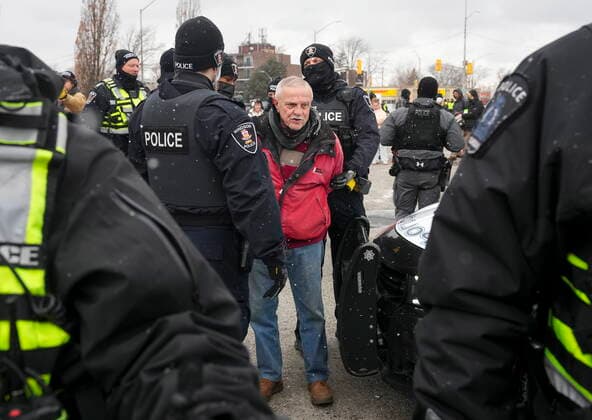 February 13, 2022, WINDSOR, ON, CANADA: A protester is arrested by as police remove truckers and supporters after a court injunction gave police the power to enforce the law after blocking the access leading from the Ambassador Bridge, linking Detroit and Windsor, as truckers and their supporters continue to protest against the COVID-19 vaccine mandates and restrictions in Windsor, Ont., on Sunday, February 13, 2022. WINDSOR CANADA  - ZUMAc35_ 20220213_zaf_c35_065 Copyright: xNathanxDenettex